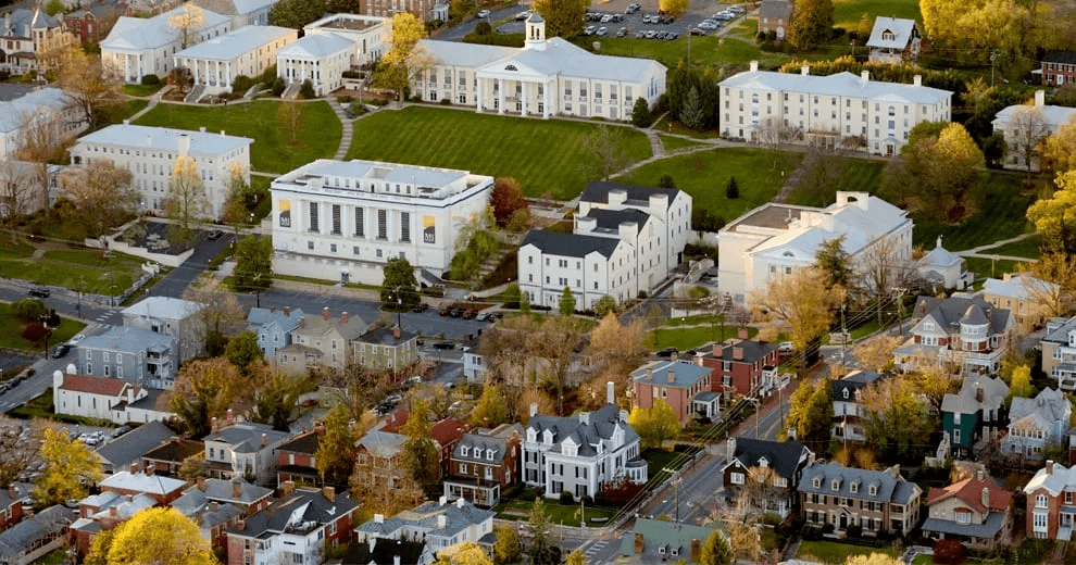 Aerial view of a college campus surrounded by residential houses and tree-lined streets.
