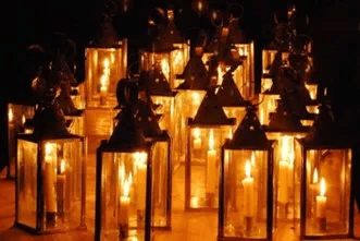A collection of illuminated lanterns with flickering candles inside.