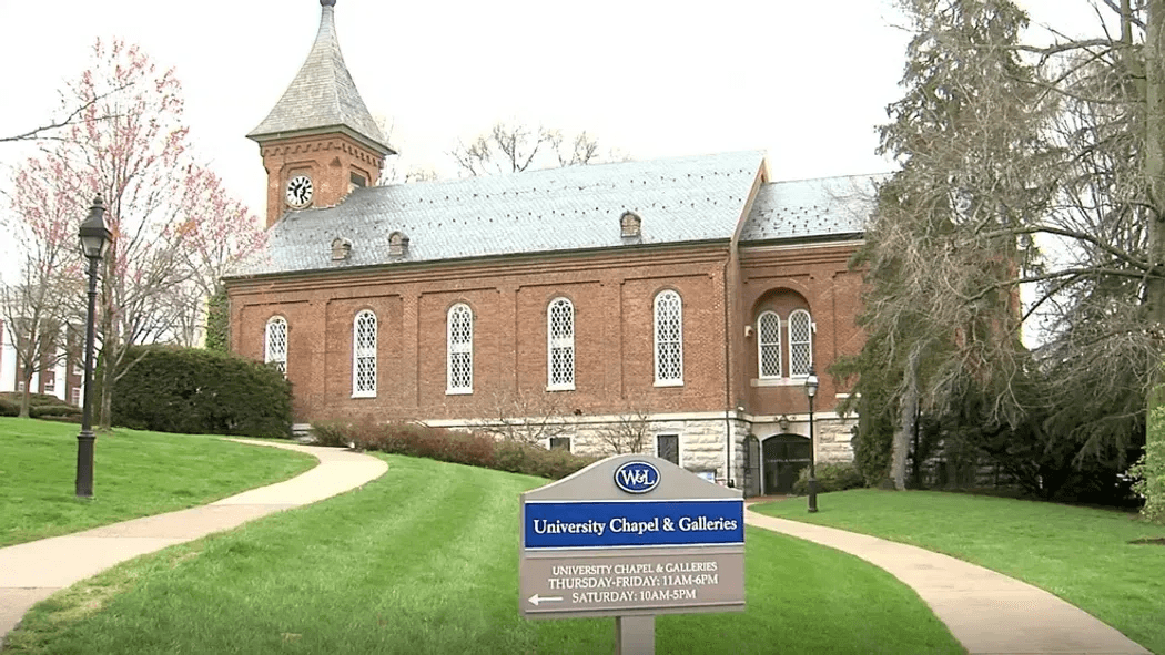 Brick chapel building with a steeple and landscaped pathways.