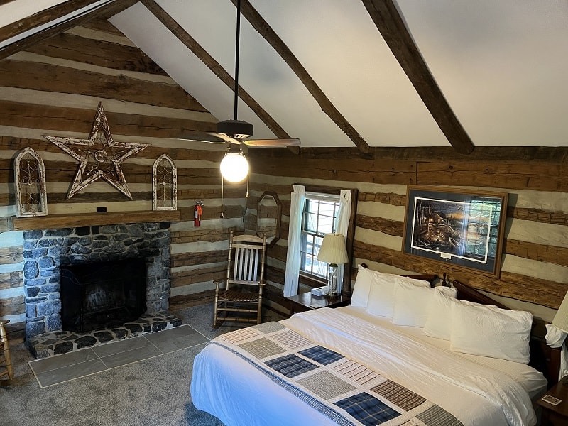 Cozy bedroom with a rustic wooden design, featuring a stone fireplace, a star decoration, and a comfortable bed.