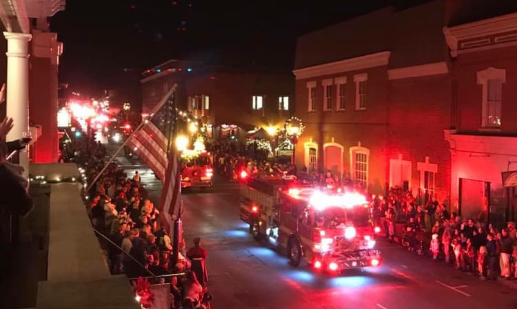 Lexington VA christmas parade as viewed from a balcony showing fire trucks and floats lit up with christmas lights